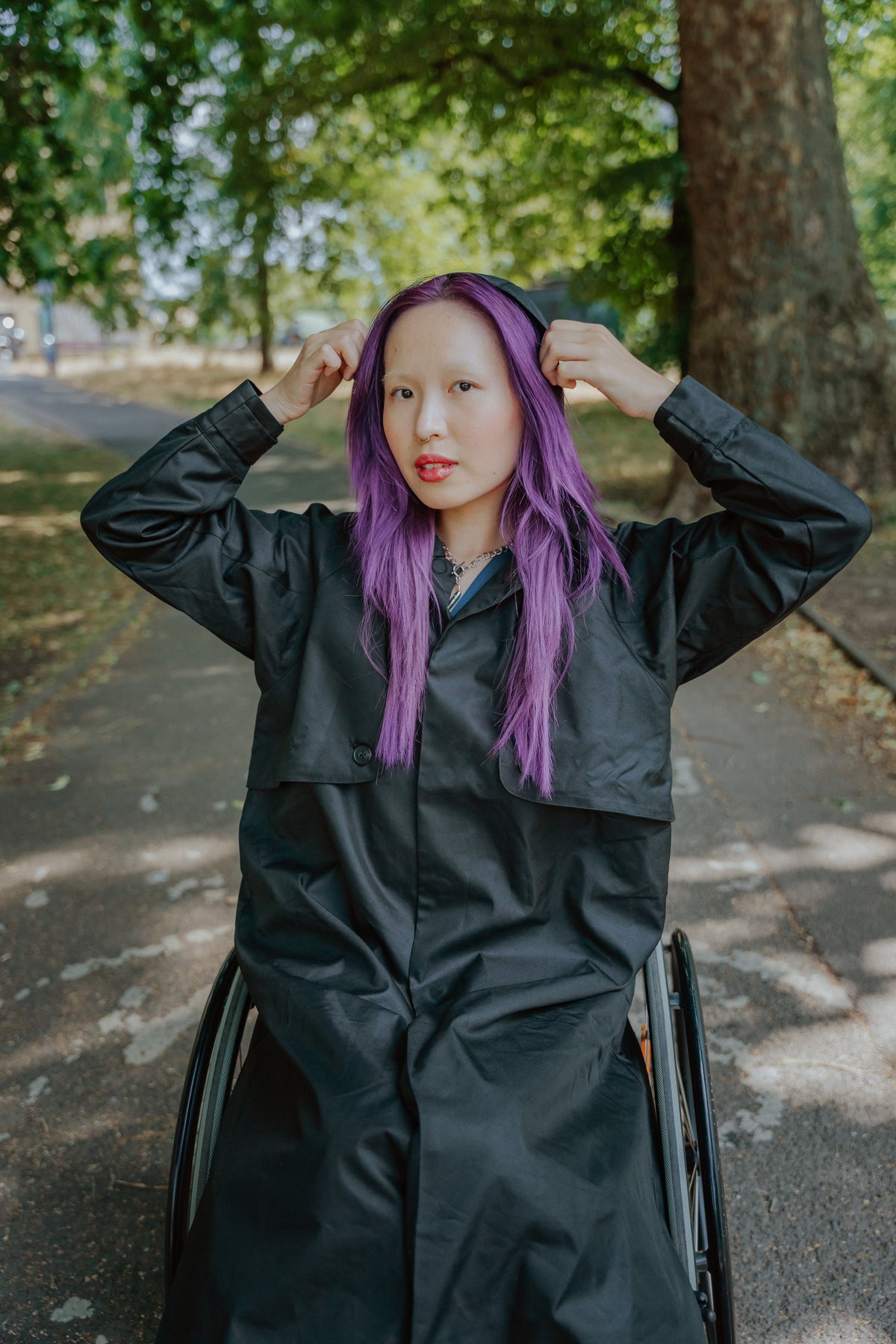 a woman in a wheelchair holding her hair