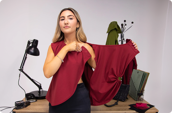 a woman holding up a red shirt